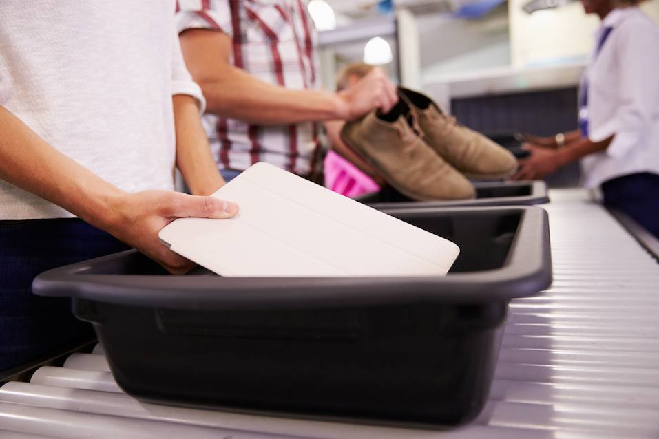 Man Puts Digital Tablet Into Tray For Airport Security Check